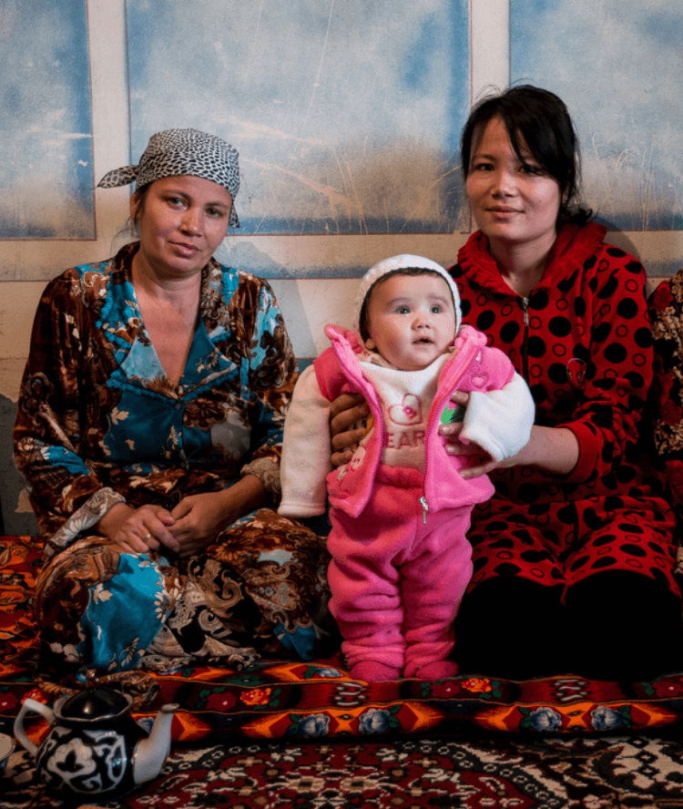 Two woman holding a baby